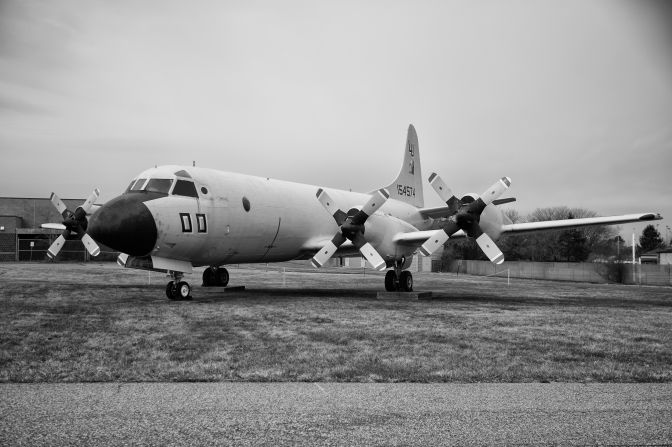 P-3B Orion aircraft, parked on grassy lawn.