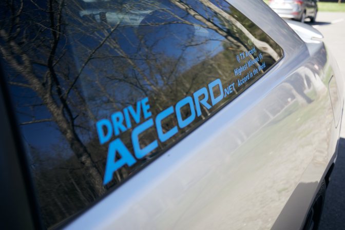 Window sticker on 2003 Honda Accord that reads DRIVE ACCORD @TX ACCORD. HIGHEST MILEAGE V6 ACCORD IN THE WORLD.