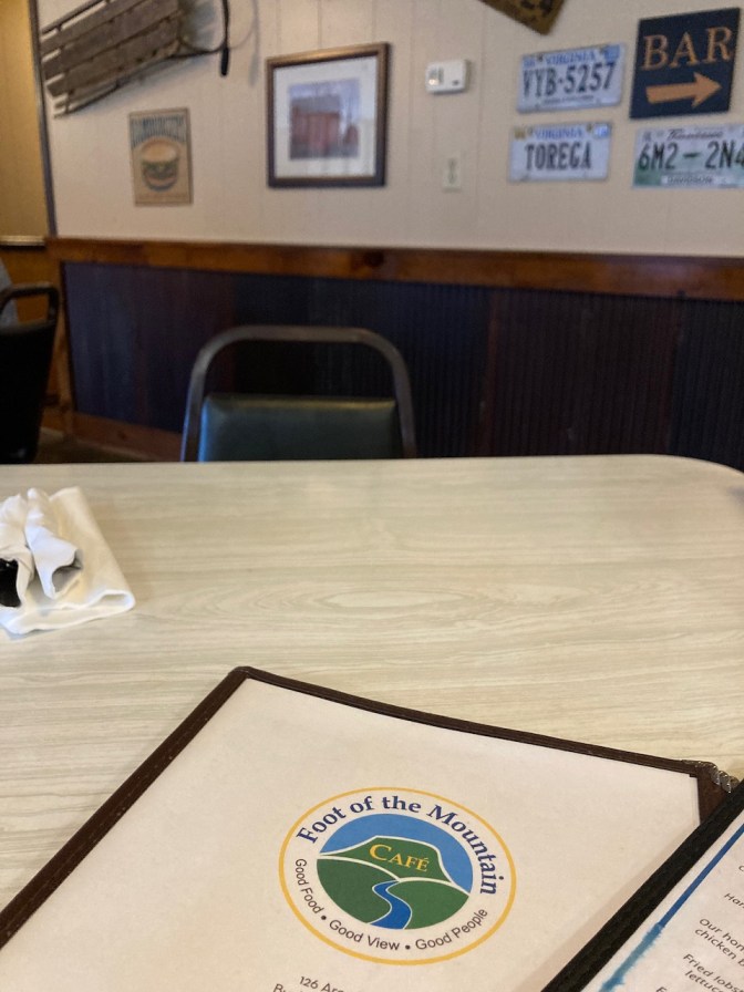 Menu on formica table, with wall in background with licenses plate decorations.