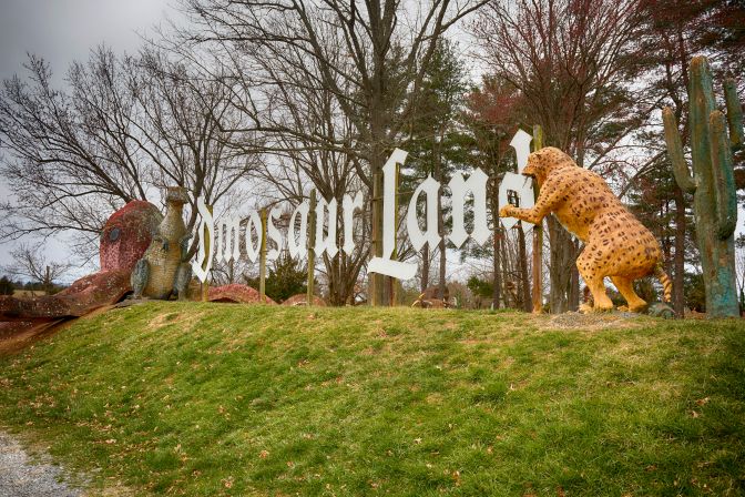 Dinosaur Land entrance sign, surrounded by dinosaur sculptures.