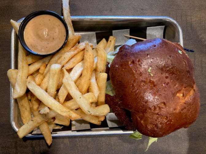 Fried chicken sandwich on plate, with fries and fry sauce.