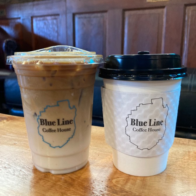 Iced coffee (left) and hot coffee (right) on wooden table.