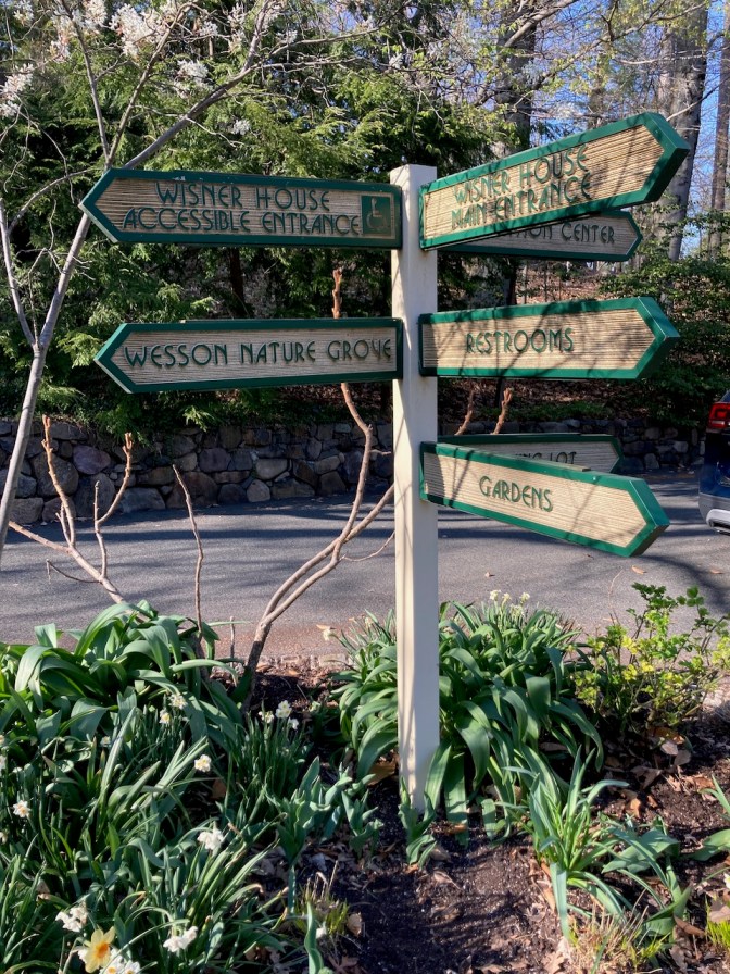 Sign post with numerous signs pointing to different spots on the property.