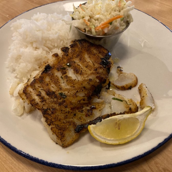Cajun-spice covered cod, with rice and coleslaw.