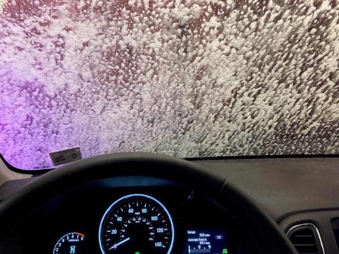 View of dashboard and front windshield of Honda HR-V in car wash.