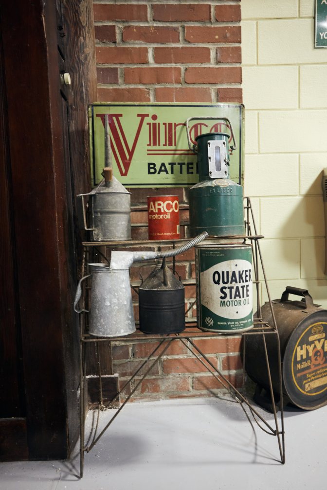 Metal wire shelves holding oil cans.