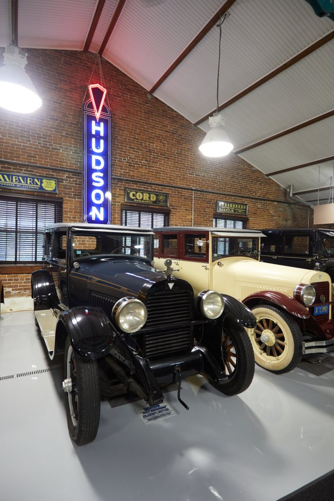 Hudson car in front of Hudson sign.
