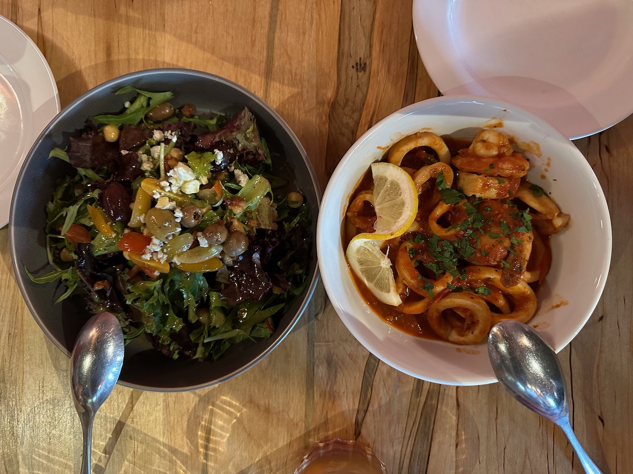 Bowl with Insalata Mista (left) and calamari in marinara sauce (right).