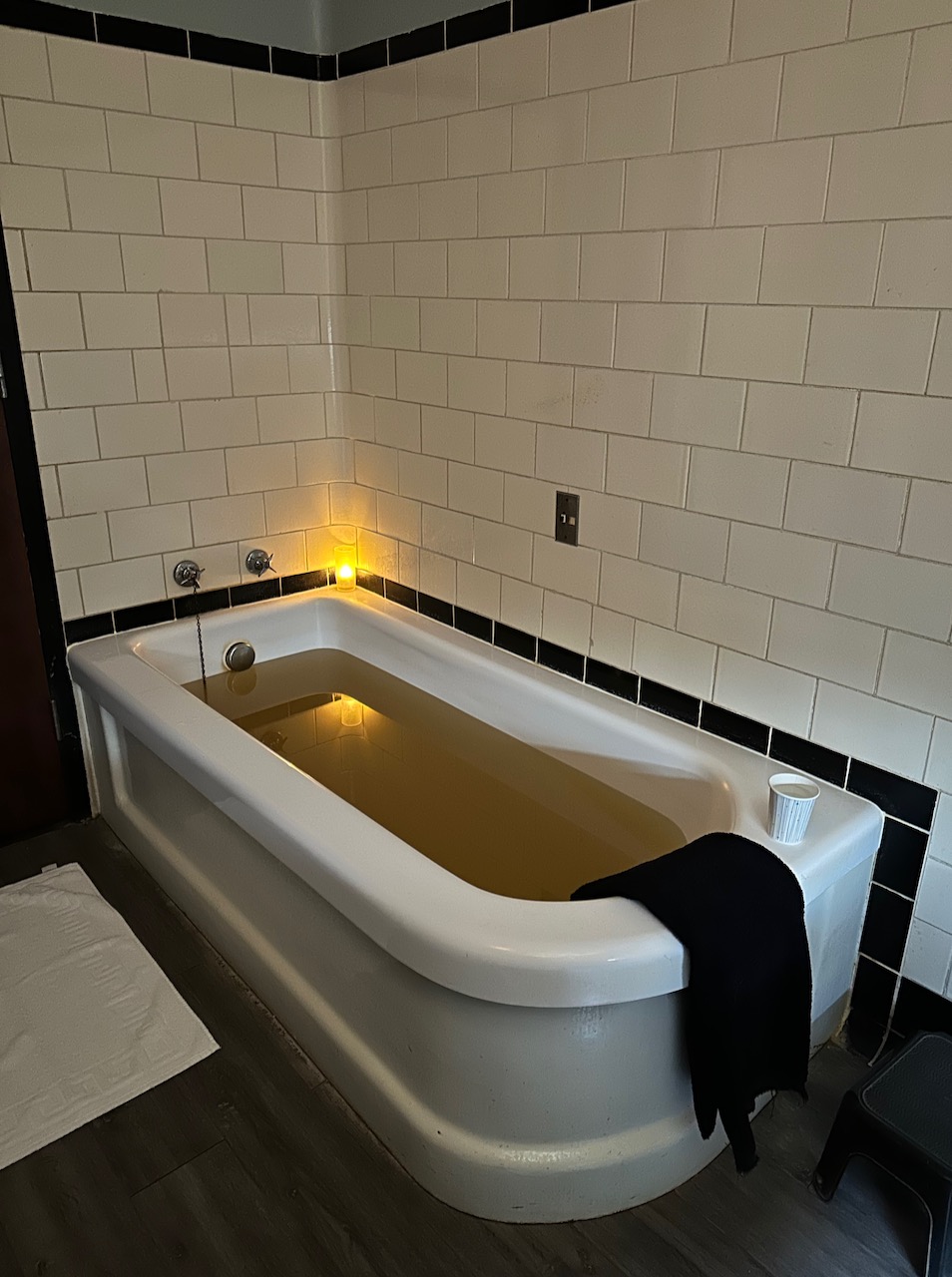 Bathtub filled with brown water.