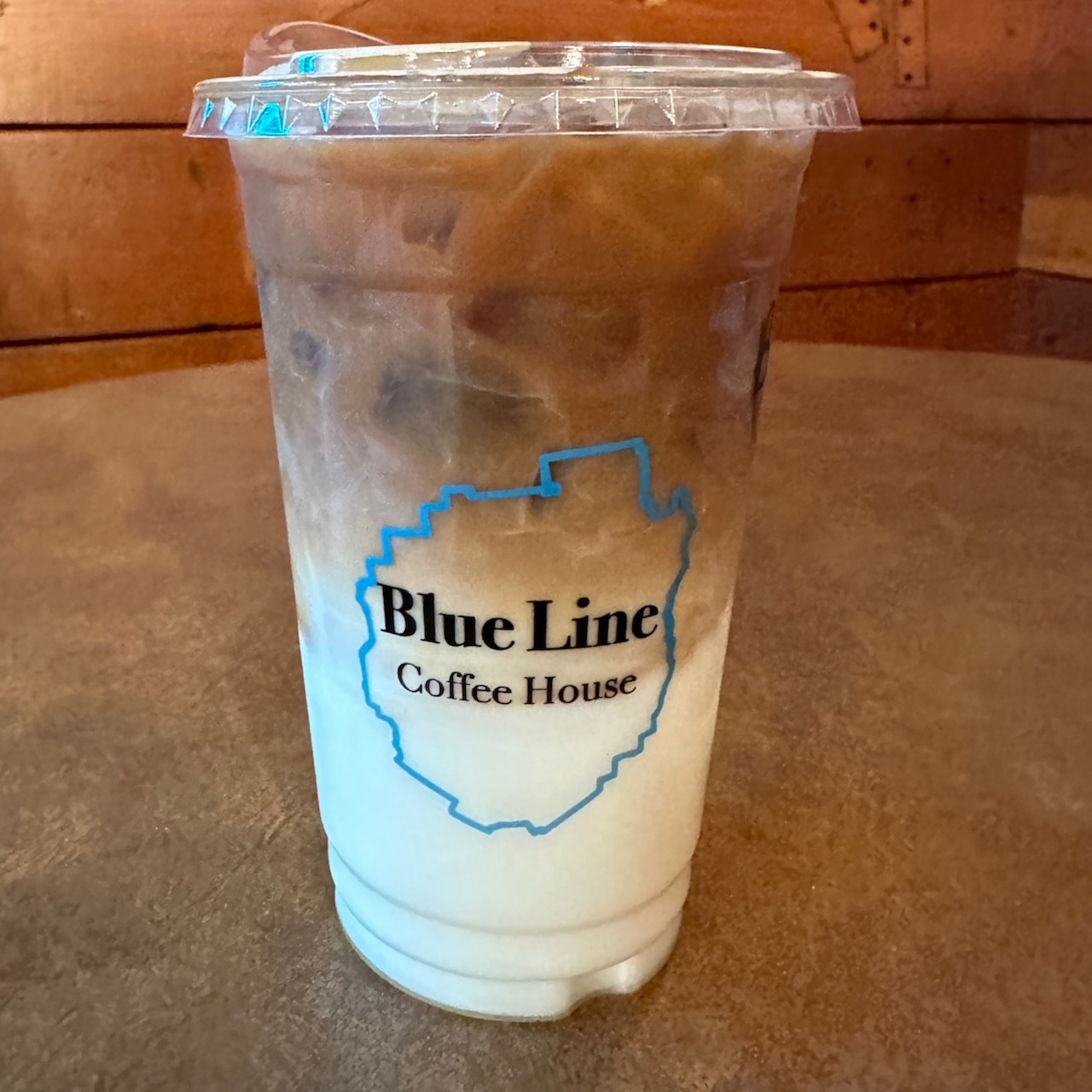 Birch iced latte in plastic cup that reads BLUE LINE COFFEE HOUSE.