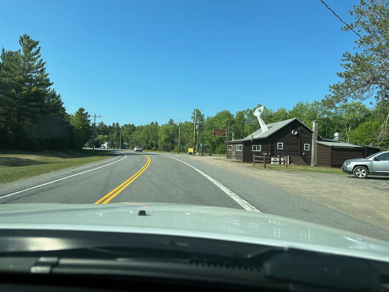 Two-lane road with Wigwam Tavern on right side of road.