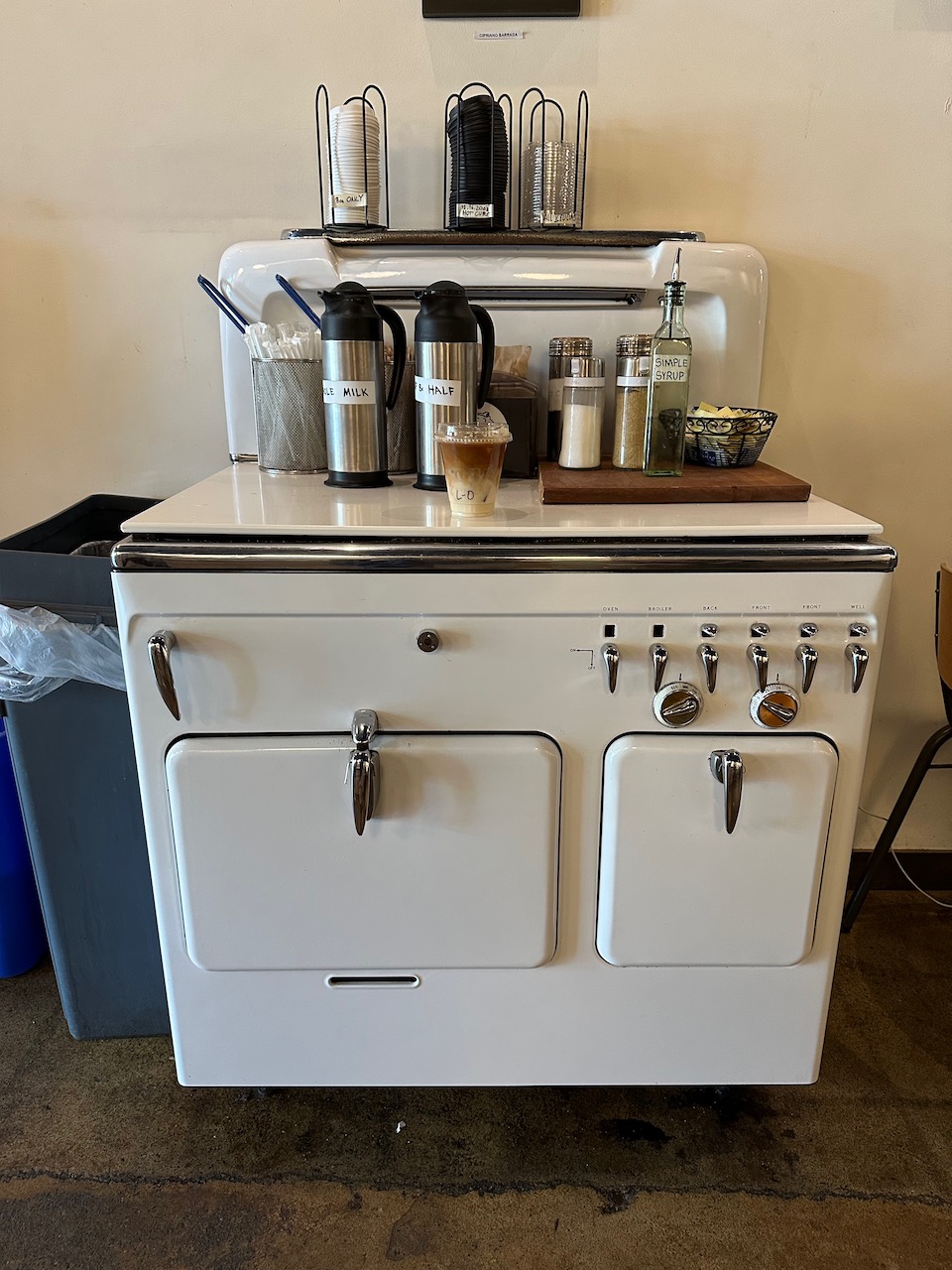 Old-style stove with coffee bar on top of it.