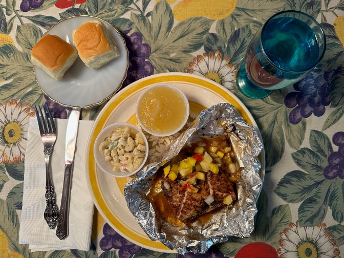 salsa-covered mahi-mahi on plate, with sides of bread, macaroni salad, and applesauce.