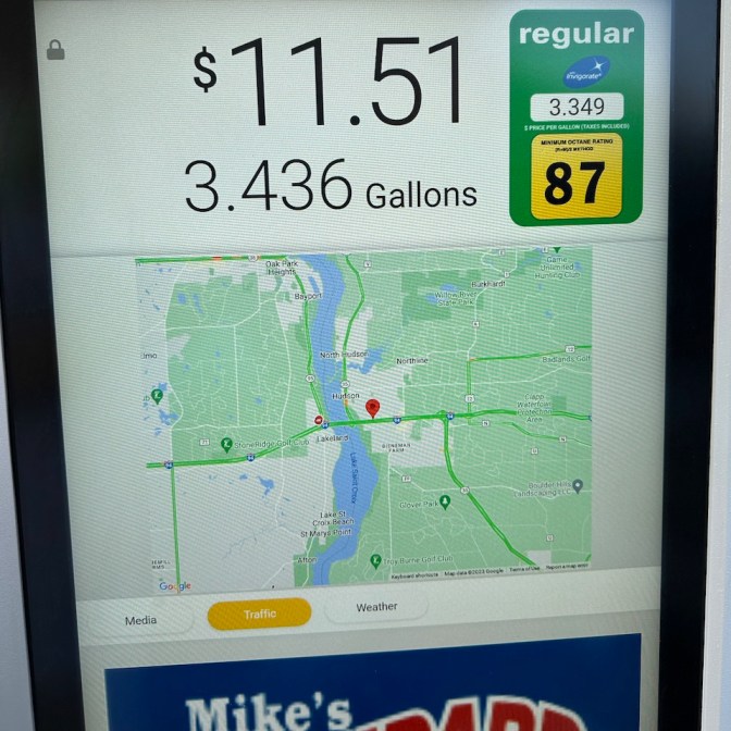 Gas station pump with display showing price of gas, along with traffic map.