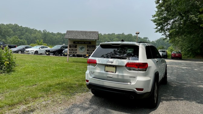 Jeep Grand Cherokee parked near entrance to Raptor Trust.