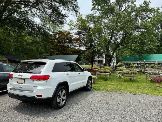 2014 Jeep Grand Cherokee parked in front of farm stand.