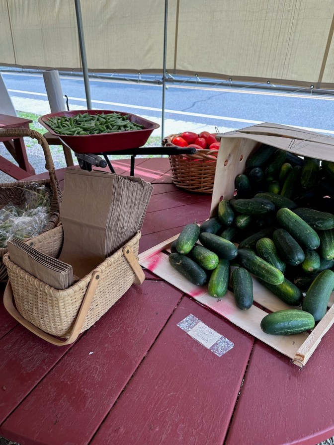 Cucumbers, green beans, tomatoes on table.