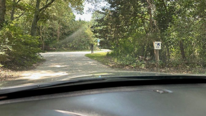 Gravel path, with sign beside road with picture of bird and number 22.