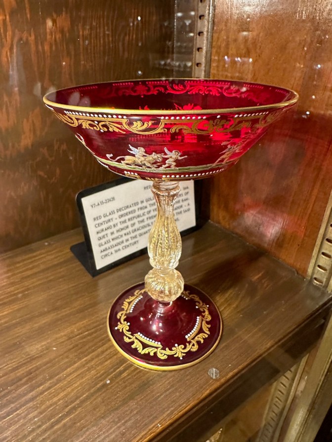 Ornate, decorated red and black wine glass.