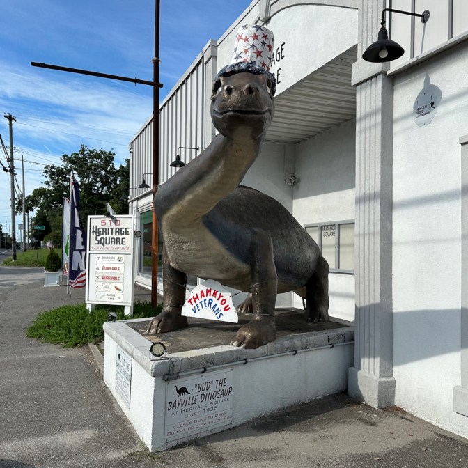 Bud the Bayville Dinosaur statue, wearing July 4th hat.