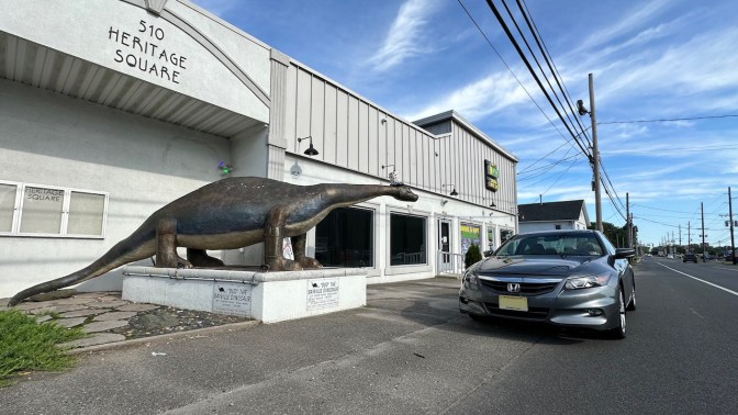2012 Honda Accord parked in front of dinosaur statue.