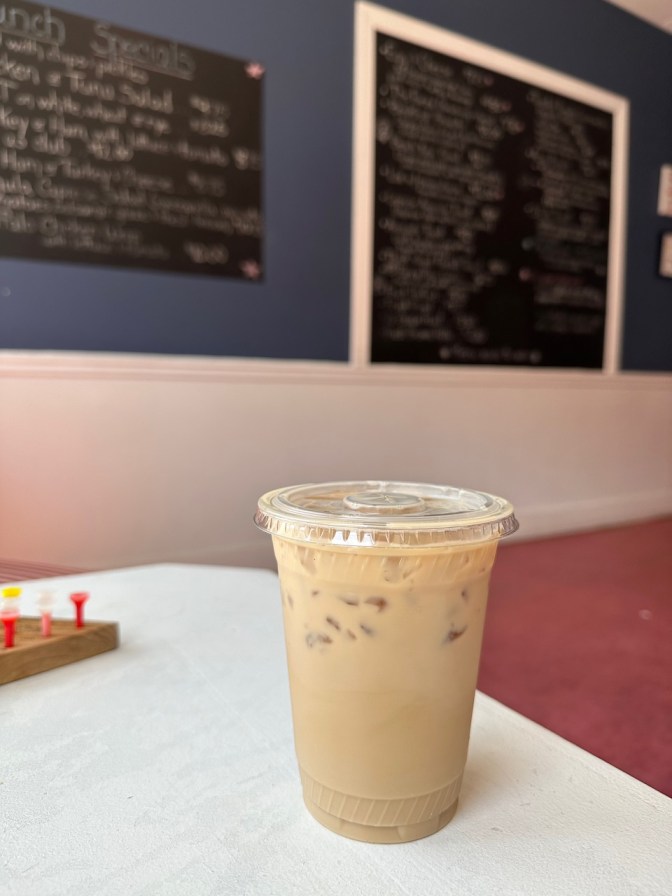 Iced coffee in plastic cup on cafe table.