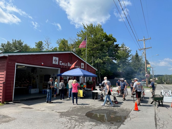 Eagle Bay Fire House, with tents and crowds of people at entrance.