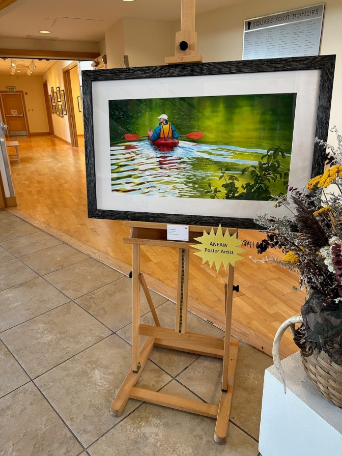 Framed painting of The Kayaker, a man in a kayak on a lake.