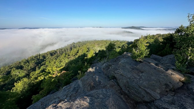 View of summit of Rocky Mountain and cloud inversion above Fourth Lake in distance.