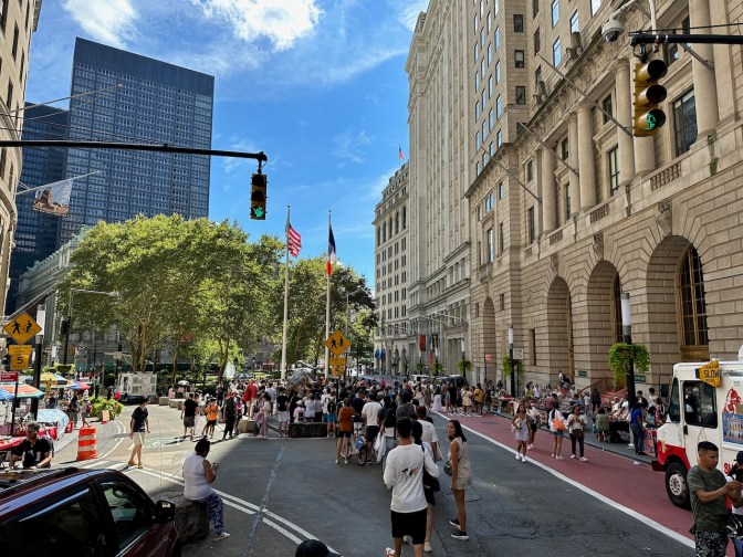 Line of tourists waiting to stand beside Charging Bull.
