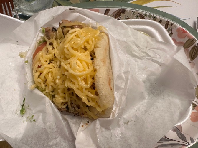 Chicken arepa on paper plate.