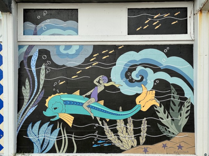 Mural of woman riding dolphin.