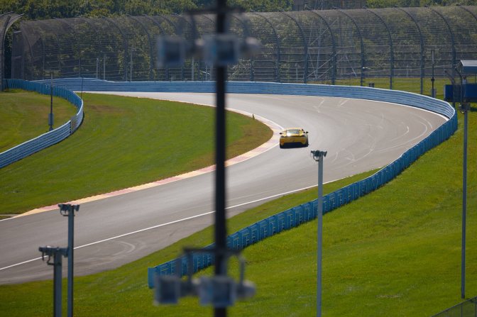 View of car climbing hill into corner of race track.