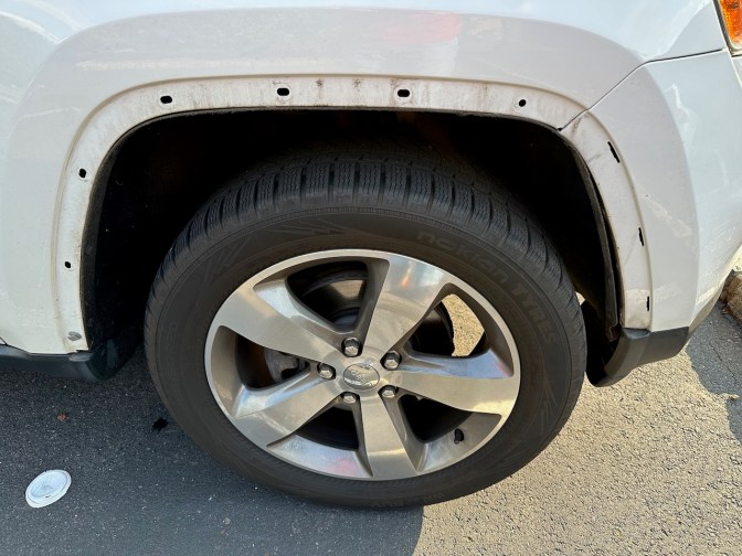 Jeep Grand Cherokee front right fender missing plastic trim.
