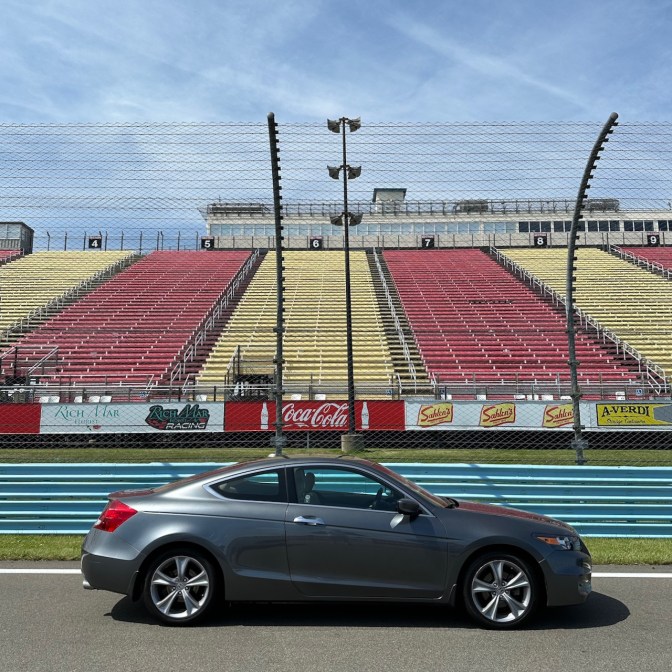 2012 Honda Accord coupe parked in front of Watkins Glen grandstands.