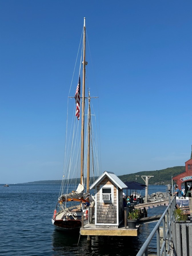 Sailboat docked beside pier.