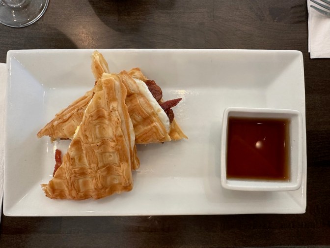 Waffle breakfast sandwich on plate.