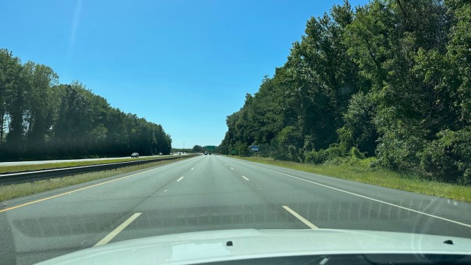View of I-295 under sunny skies from behind dashboard of 2014 Jeep Grand Cherokee.