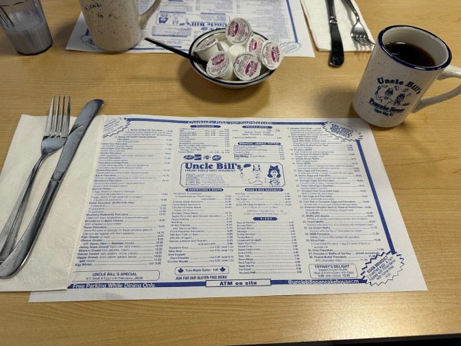 Uncle Bill's placemat menu on table, beside a cup of coffee.