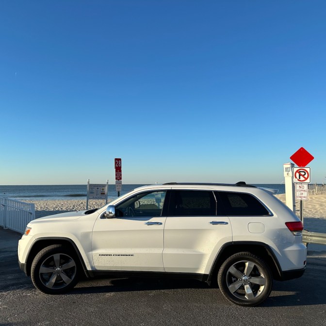 2014 Jeep Grand Cherokee parked beside beach.
