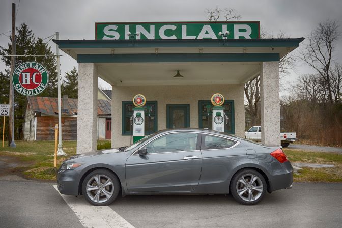 2012 Honda Accord coupe parked in front of historic Sinclair gas station.
