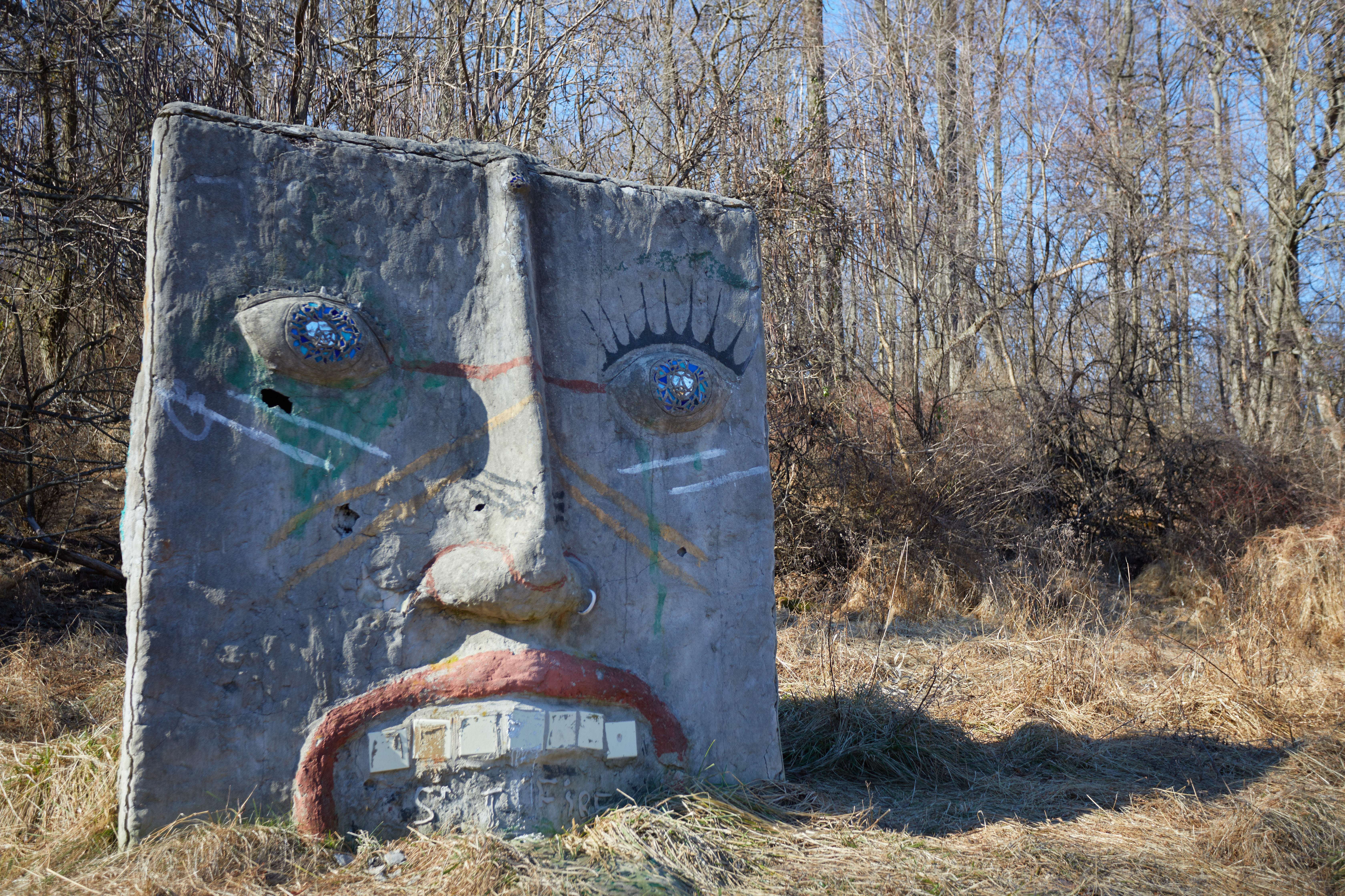 Sculpture of human face on square stone.