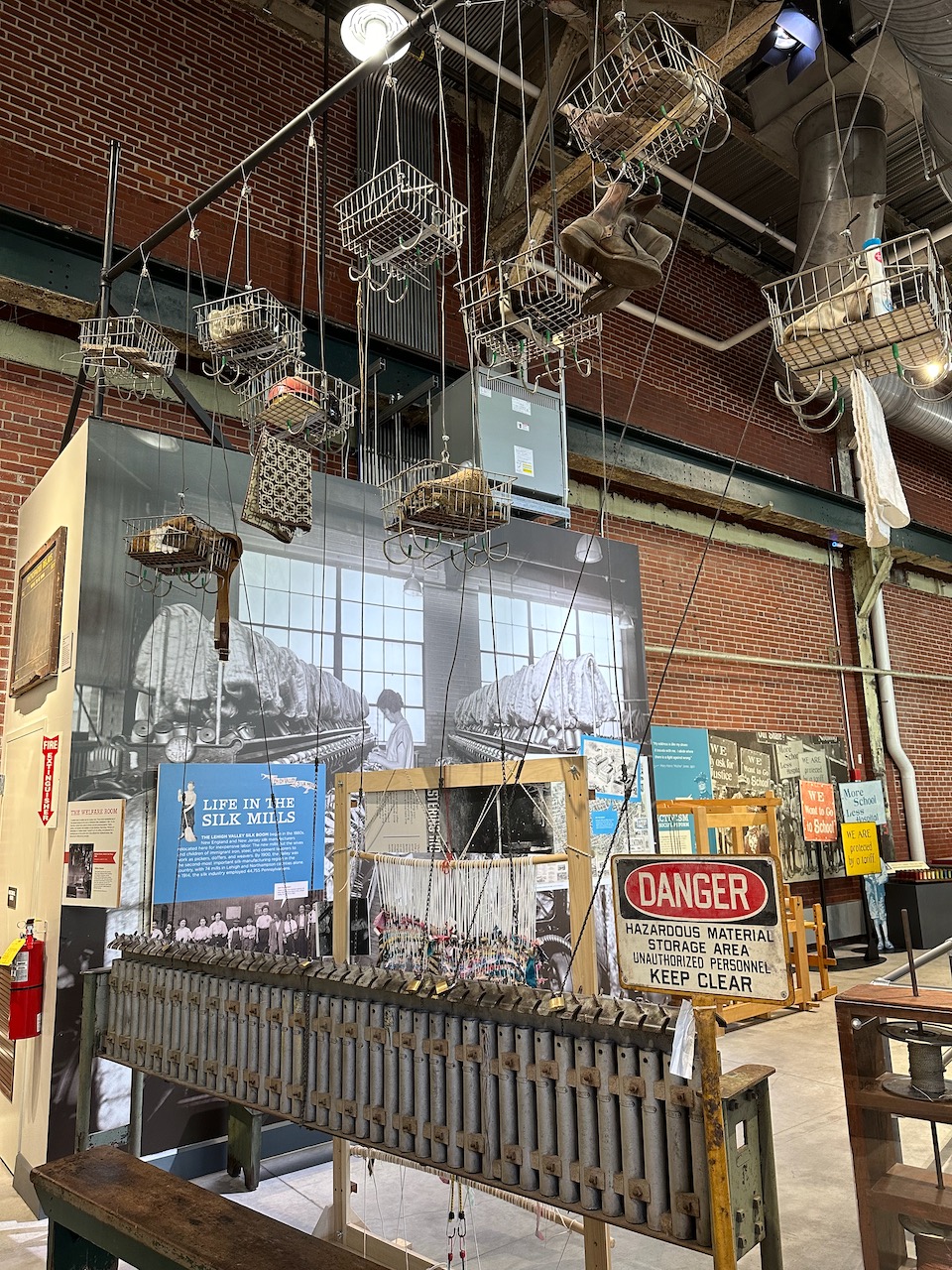 Replica of welfare room from steel mill, with belongings hanging in baskets.