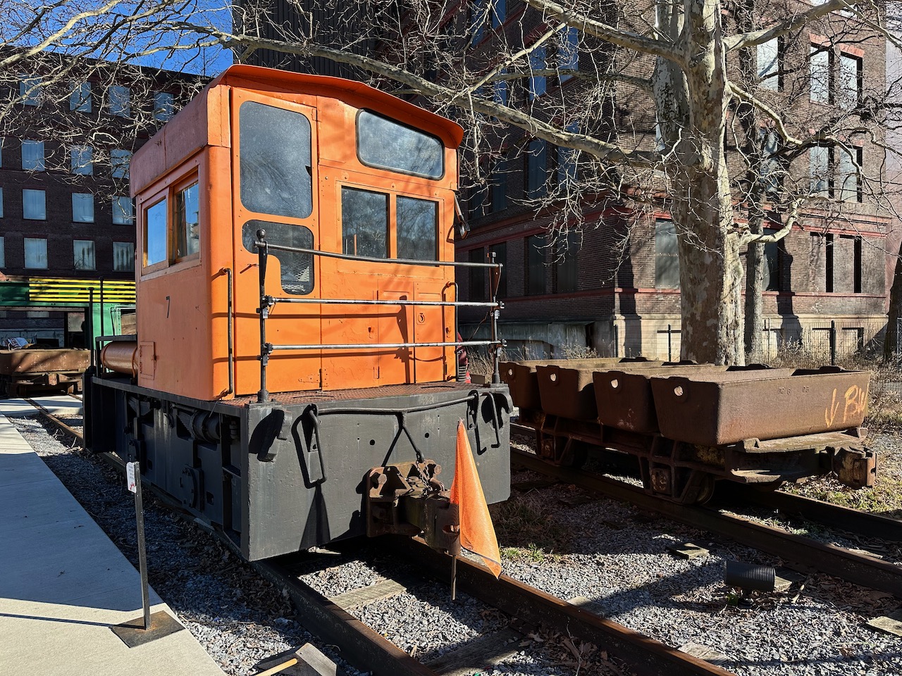 Dinky next to freight car carrying steel.