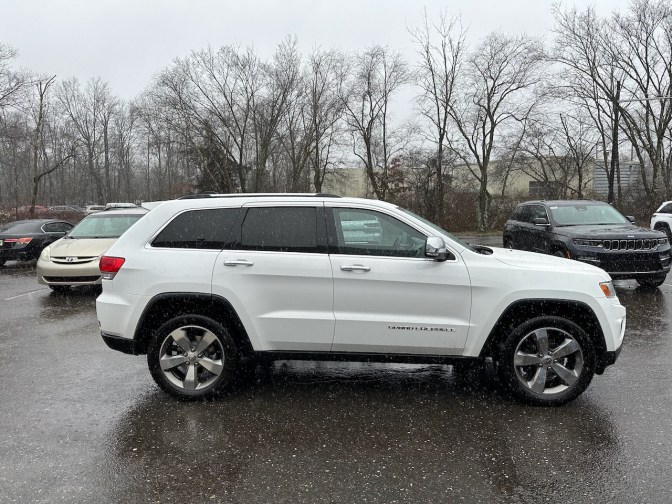 2014 Jeep Grand Cherokee parked in parking lot in a rain storm.