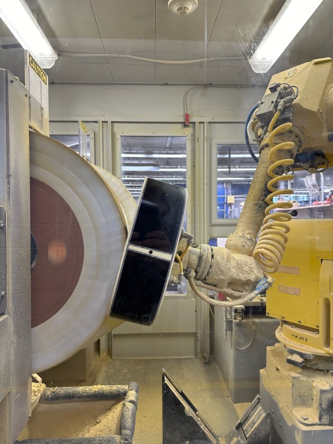 Buffing machine working on guitar body.
