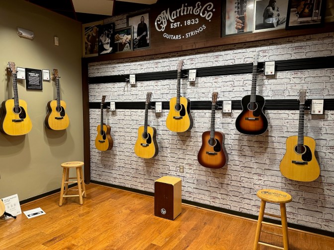 Guitars hanging from walls in playing room.