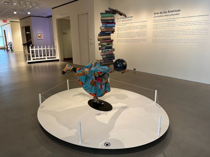 Statue of girl with stack of books on back.