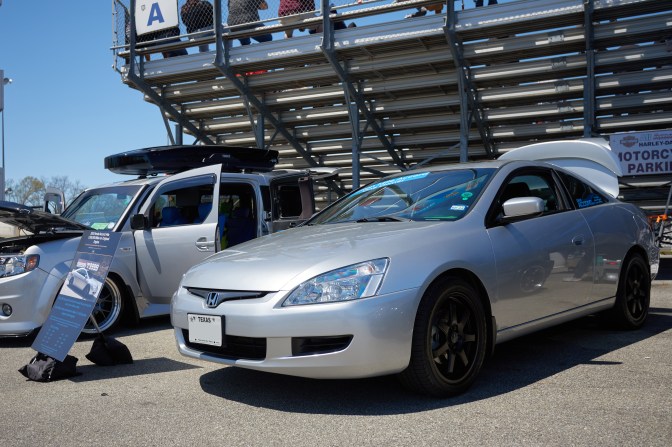 2003 Honda Accord coupe parked behind bleacher stands.
