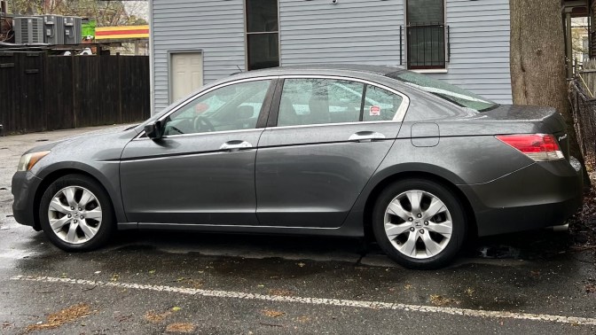 2010 Honda Accord sedan parked in front of house.